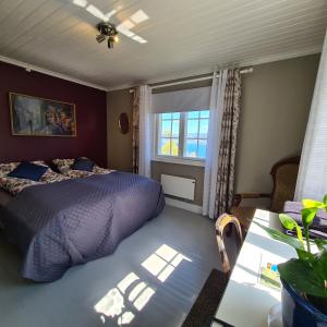 a bedroom with a bed and a window and a table at VILLA HASSELBAKKEN in Eidsvoll