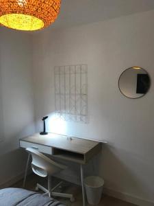 a desk in a room with a lamp and a mirror at Bel appartement 6p Tours Centre in Tours