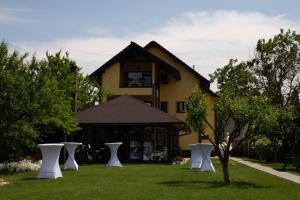 a house with white chairs in the yard at JANINE GARDEN in Braşov