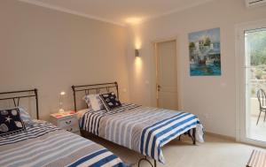 een slaapkamer met twee bedden en een raam bij Villa Christianna in Ágios Stéfanos +14 foto's