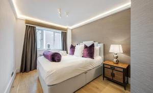 a bedroom with a large bed with purple pillows at Flat 8 in London