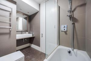 a bathroom with a shower and a toilet and a sink at Flat 8 in London