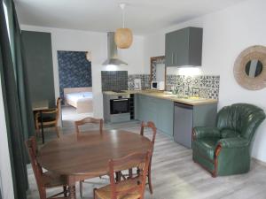 a kitchen and living room with a table and a kitchen and a dining room at Le gîte des fresques in Saint-Savin