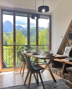 comedor con mesa y sillas y ventana grande en Villa Tatrydom, en Zakopane