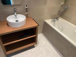 a bathroom with a sink and a bath tub at L'Escale Marine, The Originals Relais in Crozon