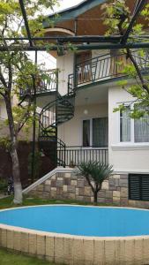 a house with a swimming pool in front of a building at Natalie's Guest house in Tbilisi City