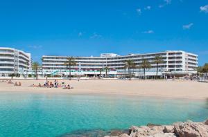 una playa con edificios y gente en la playa en INNSiDE by Meliá Wave Calviá, en Magaluf