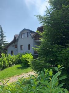 una gran casa blanca con árboles delante de ella en Villa Zala, en Zalakaros