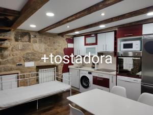 a kitchen with white appliances and a stone wall at Casa al lado del mar in Vilagarcia de Arousa
