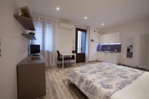 a bedroom with a bed and a desk with a television at APPARTAMENTI MUSEO 3 in Verona