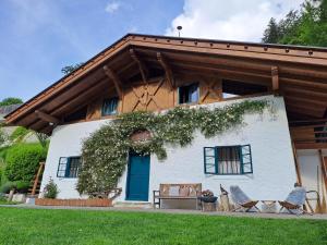 een wit huis met een blauwe deur en twee stoelen bij Chalet Passeier - ZOLL in Saltusio