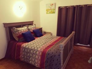 1 dormitorio con 1 cama con almohadas azules en Mas de Gaussel en Cabrières