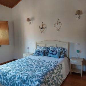 1 dormitorio con 1 cama con sábanas azules y corazones en la pared en Quinta Vale do Nox, en Serrazes