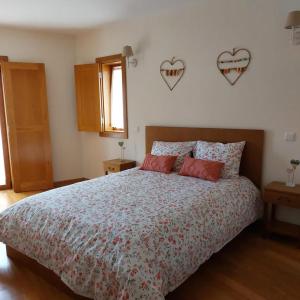 a bedroom with a bed with two hearts on the wall at Quinta Vale do Nox in Serrazes +32 photos