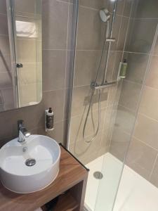 a bathroom with a sink and a shower at L'Escale Marine, The Originals Relais in Crozon