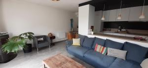 sala de estar con sofá azul y cocina en Maison moderne mitoyenne exposée plein sud avec terrasse en Trégastel