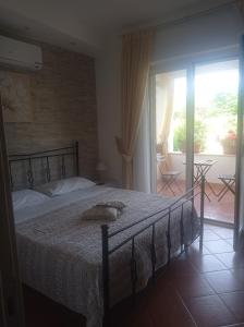 a bedroom with a bed and a balcony with a view at B&B Le Rose in Santa Maria di Castellabate