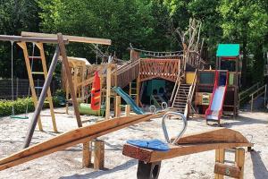 einen Spielplatz mit einer Holzrutsche im Sand in der Unterkunft Het Uilennest in Durbuy in Durbuy