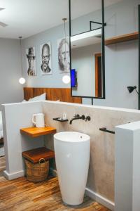 La salle de bains est pourvue d'une baignoire blanche et d'un lavabo. dans l'établissement Burundi Palace Boutique Hotel, à Bujumbura