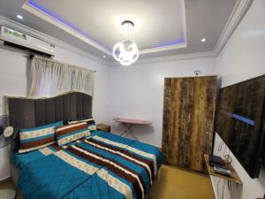 um quarto com uma cama com um edredão azul em Dinero Beryl(One Bedroom) Apartment em Lagos