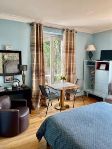 um quarto com uma mesa e cadeiras e uma janela em Le Clos des Princes em Châtenay-Malabry