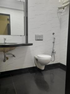 a bathroom with a toilet and a sink at UK's Resort in Talegaon Dābhāde