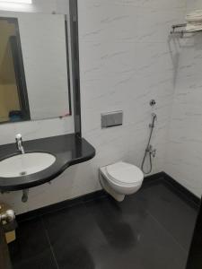a bathroom with a toilet and a sink at UK's Resort in Talegaon Dābhāde