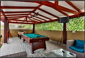 a pool table on a patio with a roof at Happy stay villa in Grand'Anse Praslin