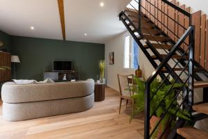 sala de estar con escalera y sofá en Domaine Baruteau, en Soustons