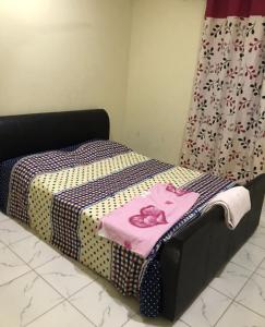 Una cama con una camisa rosa encima. en Marie's residence, en Medina Suware Kunda