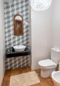 a bathroom with a sink and a toilet and a mirror at Apartamento T3 - D'ouro a Vista in Peso da Régua