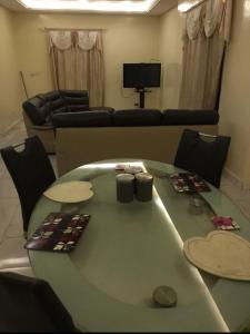 uma sala de estar com uma mesa e um sofá em Marie's residence em Medina Suware Kunda