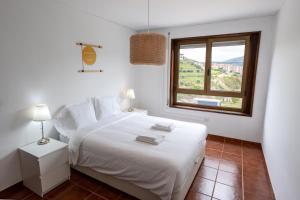 Un dormitorio blanco con una cama blanca y una ventana en Apartamento T3 - D'ouro a Vista, en Peso da Régua