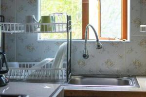 a kitchen sink with a faucet next to a window at Charming 1-Bed Penthouse in Karen Nairobi in Nairobi