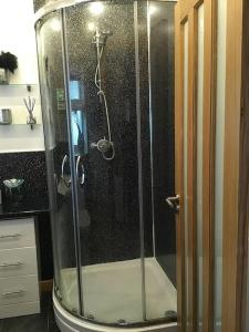 a shower with a glass door in a bathroom at Bonnie Bide Huntly Aberdeenshire in Huntly