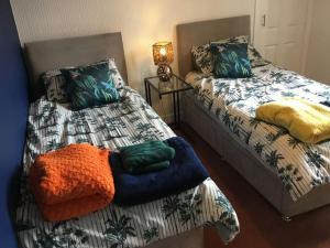 a room with two beds with colorful pillows on them at Bonnie Bide Huntly Aberdeenshire in Huntly