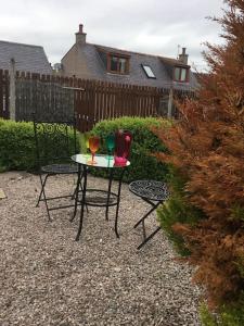 uma pequena mesa com duas cadeiras e um copo de vinho em Bonnie Bide Huntly Aberdeenshire em Huntly