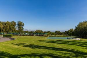 um grande campo relvado com uma piscina num parque em Lord Charles Hotel em Somerset West