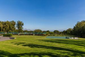a large grassy field with a pool in a park at Lord Charles Hotel in Somerset West