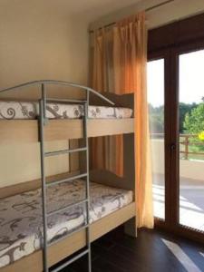 a bunk bed room with two bunk beds and a window at Villa Dimitrios in Kriopigi