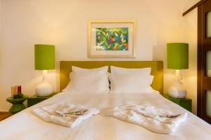 1 dormitorio con 2 toallas en una cama con 2 lámparas en Salvator Villas & Spa Hotel, en Parga