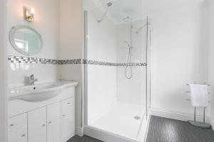 Un baño blanco con ducha y lavabo. en Moonbeams, en St Ives 49 fotos más