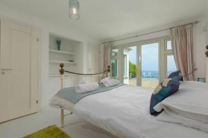 Un dormitorio con una cama con vista al mar. en Moonbeams, en St Ives