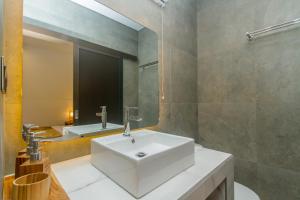 uma casa de banho com um lavatório branco e um espelho. em Rahayu Guest House Ubud em Ubud