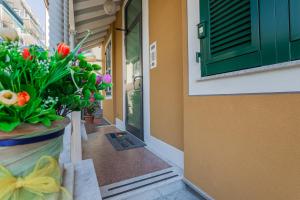 eine Tür mit einer Blumenvase an der Seite eines Gebäudes in der Unterkunft Residence Villa Alda in Pietra Ligure