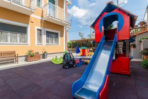 a playground with a slide in a yard at Residence Villa Alda in Pietra Ligure