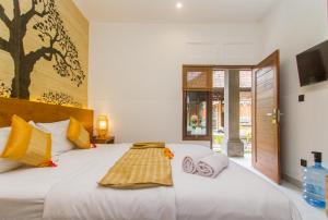 a bedroom with a large white bed with towels on it at Rahayu Guest House Ubud in Ubud