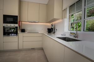 une cuisine avec des armoires blanches et un évier dans l'établissement Bella Casa, à Vieira do Minho