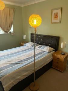 a bedroom with a bed with a lamp next to it at Churchbury Eltham in Eltham