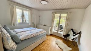 um quarto com uma cama e duas janelas em The Swiss Paradise 2 Apartment with Garden, Whirlpool, and Mountain Panorama em Wirzweli